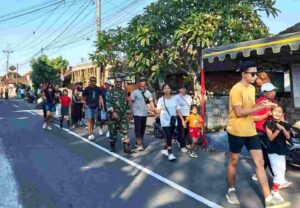 Semarak HUT RI ke-81, Babinsa Belumbang Jaga Keamanan Jalan Santai Warga Desa